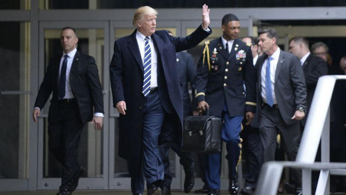 Phụ tá xách chiếc vali hạt nhân theo ông Trump.