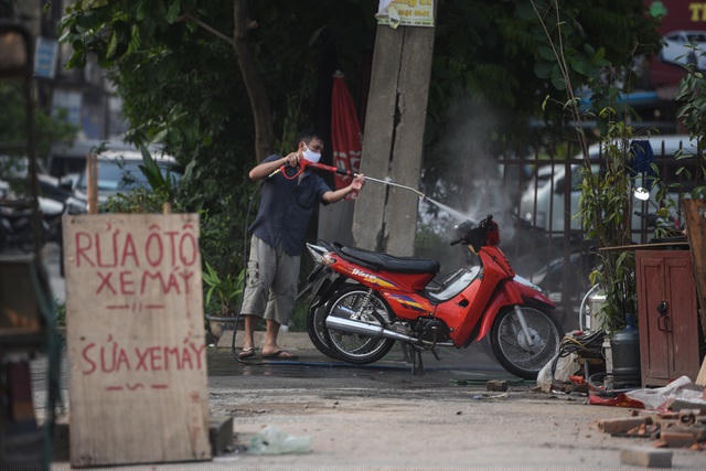 Một hàng rửa xe máy trên phố Minh Khai (quận Hai Bà Trưng).