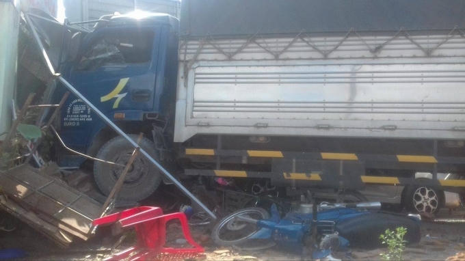 Xe máy bị cuốn vào gầm xe tải.