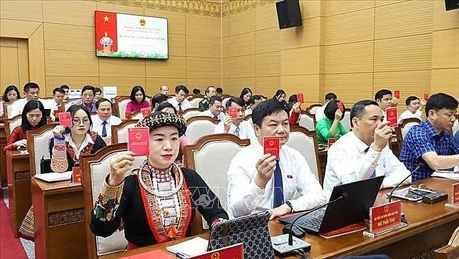 Đại biểu HĐND tỉnh Yên Bái và đại biểu HĐND tỉnh Lào Cai biểu quyết thông qua Nghị quyết Kỳ họp với sự thống nhất cao. (Ảnh: TP).