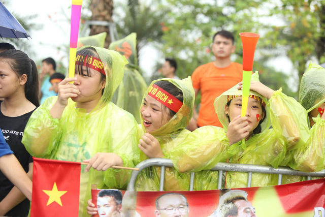 Cổ động viên đội mưa chờ đón những người hùng đội Olympic.