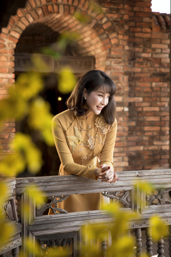 Các gam màu nổi bật với sắc độ trầm hơn như cam đất, đỏ đất,... là gợi ý Thanh Mai dành tặng các chị em phụ nữ trung niên. Loạt đá, cườm đính kết dọc theo tà áo tạo cảm giác chiều dài cơ thể được kéo dài một cách tự nhiên.