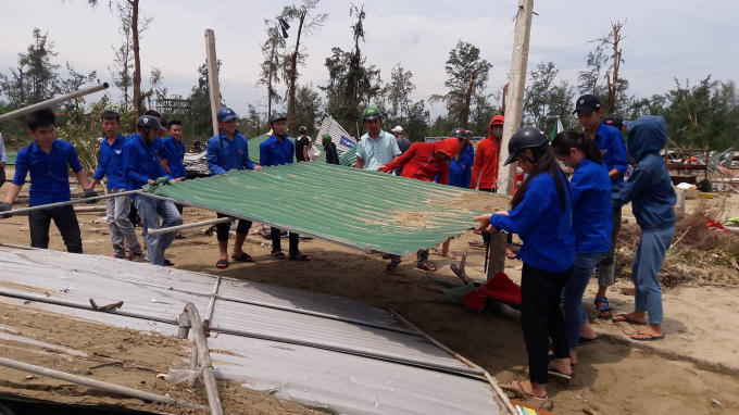 Thanh niên tình nguyện giúp dân dọn dẹp những ki ốt kinh doanh bị đổ tại Cửa Hội.