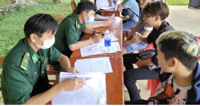 Các công dân đang hoàn tất các thủ tục trước khi được cho về địa phương. Ảnh BĐBP