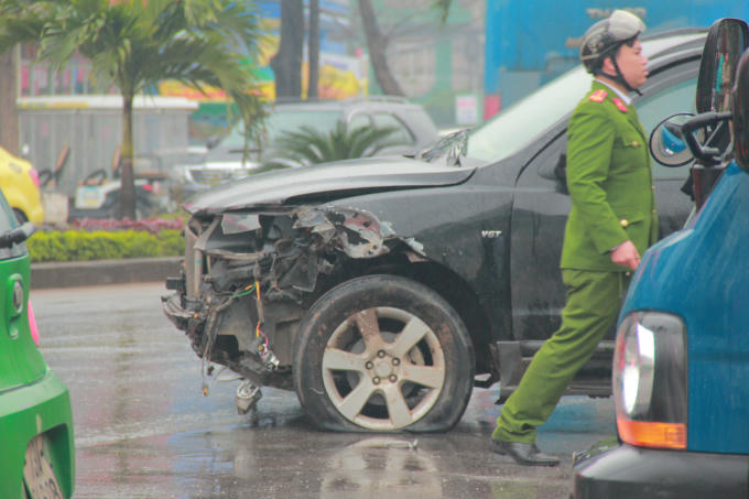 Đầu chiếc xe bị biến dạng, nổ lốp sau khi lao vào cột đèn. (Ảnh: Hải Long).