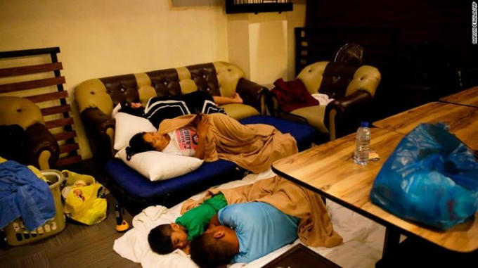 Một vài người phải trú tạm rong nhà hàng của một khách sạn sau khi phòng của họ bị tốc mái do gió lớn ở Tuguegarao.