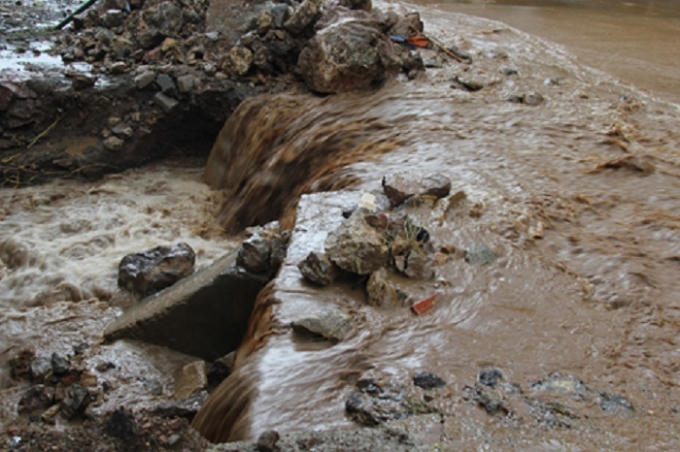 Mưa lớn đất đá bị dòng nước cuốn trôi.