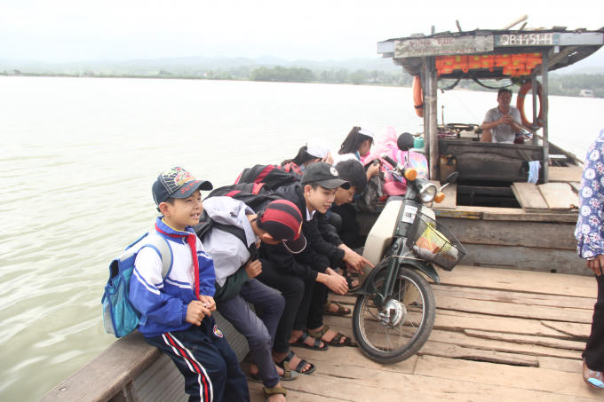 Các em học sinh hàng ngày phải đi học bằng đò mà không có phương tiện bảo hộ như áo phao. (Ảnh. Hải Long).