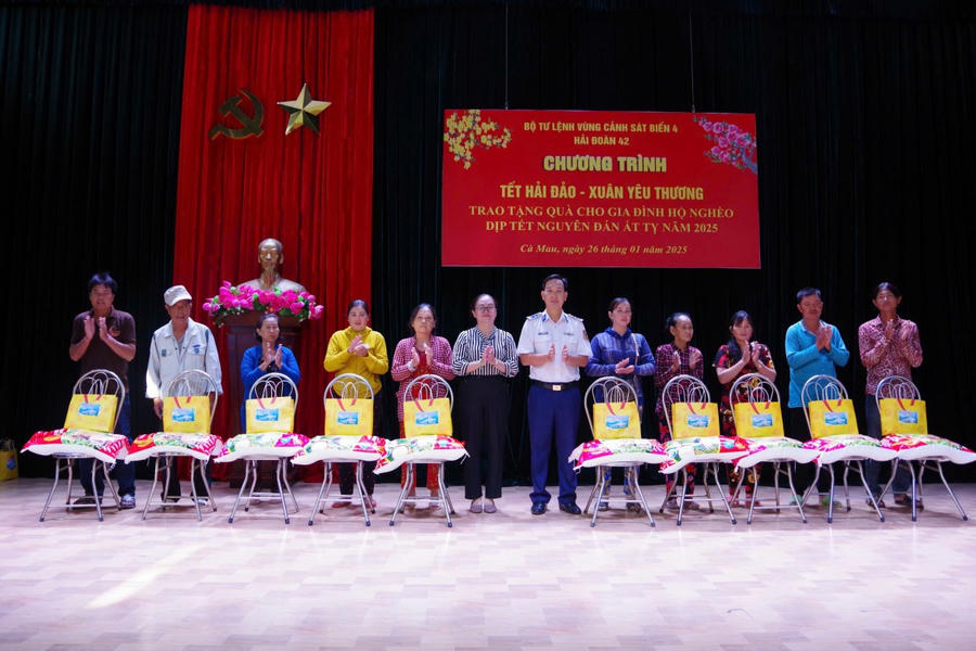 Thượng tá Lê Đức Tuấn và bà Tôn Nữ Hương Giang, Trưởng ban Dân vận huyện Năm Căn trao quà cho các hộ dân nghèo