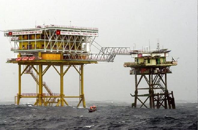 Xuồng máy của tàu Trường Sa 19 chạy vào sát chân đế nhà giàn DK1/14 để các chiến sĩ trên giàn kéo quà Tết lên bằng dây ròng rọc