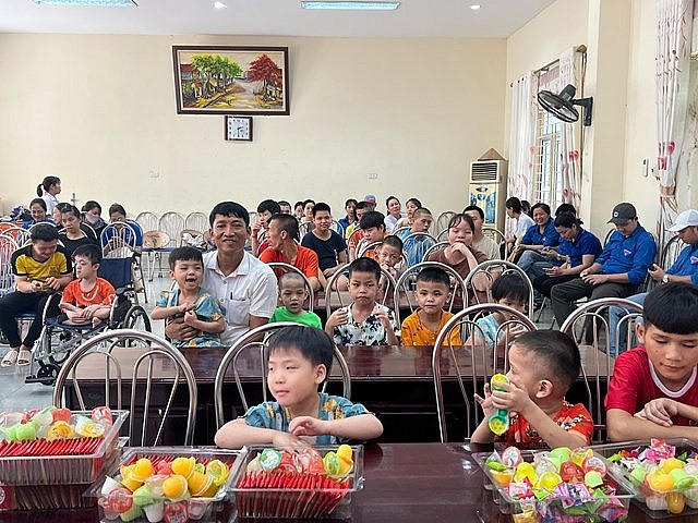 Ông Phùng Công Lợi - Giám đốc Trung tâm chăm sóc người khuyết tật Hà Nội chụp ảnh cùng các cháu ở trung tâm.