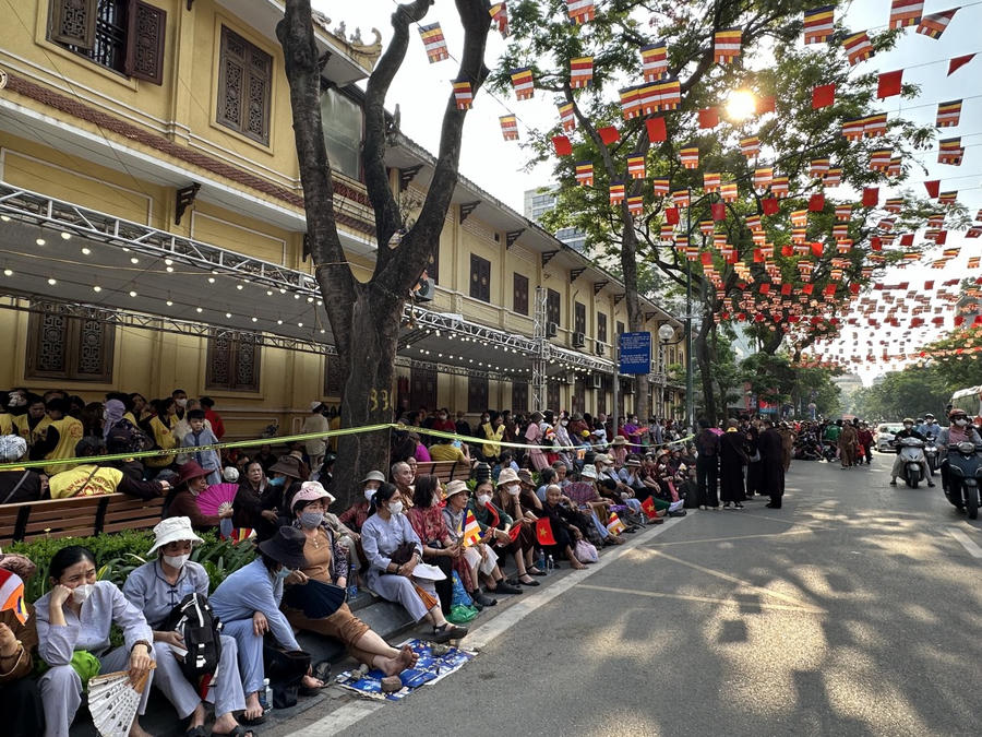 Người dân ngồi chờ dọc các tuyến đường quanh chùa Quán Sứ để mong được chứng kiến khoảnh khắc linh thiêng.