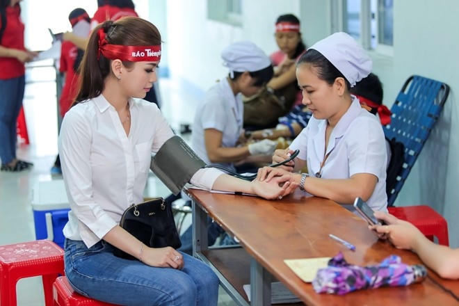Không chỉ nhiệt tình tham gia các hoạt động ở sự kiện, Á hậu Việt Nam 2014 còn tình nguyện ủng hộ quỹ máu. Trong ảnh, cô được các y tá kiểm tra sức khỏe, đo huyết áp, nhịp tim trước khi lấy máu. Sau Diễm Trang, các người đẹp khác cũng lần lượt hiến máu.