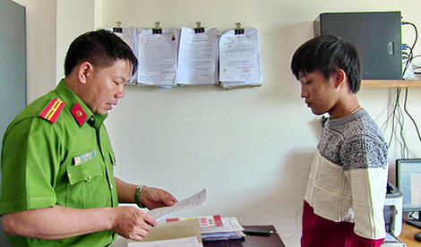 Điều tra viên tống đạt quyết định khởi tố bị can đối với Lê Thiện Bảo Huy.