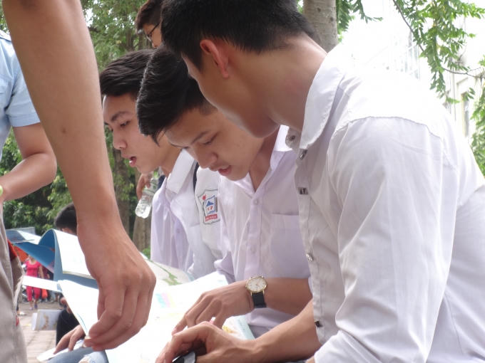 2 nam thí sinh cố gắng 'lục tìm" đáp án trong quyến Atlat Địa Lý sau khi thi xong.