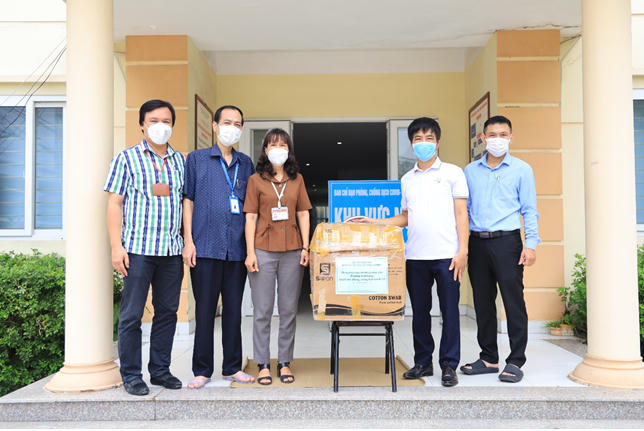 Đại diện Nhà trường trao tặng trang bị bảo hộ phòng chống Covid cho UBND Phường Vĩnh Hưng.