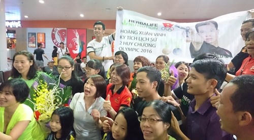 CĐV háo hức chờ đợi xạ thủ Hoàng Xuân Vinh và các thành viên khác của đội tuyển bắn súng Việt Nam. Ảnh: Như Ý
