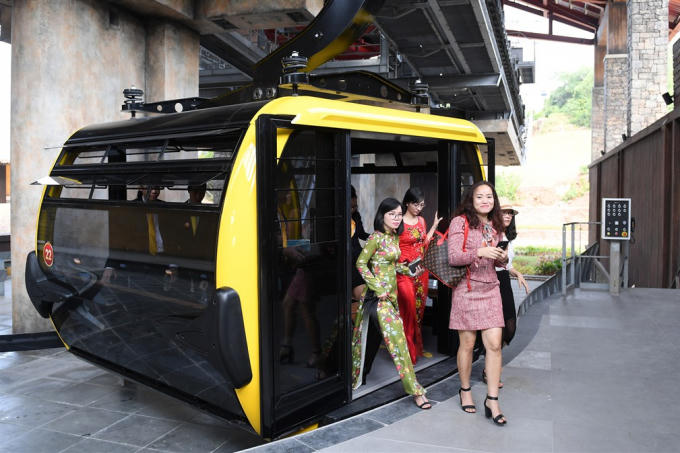 Những vị khách đầu tiên di chuyển trên cáp treo trong ngày khánh thành.