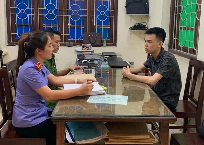 Đối tượng Phạm Viết Trung (áo đen) tại cơ quan công an.