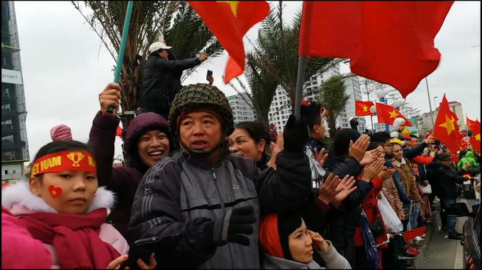 Người dân với cờ, băng rôn chào đón các cầu thủ U23 Việt Nam.