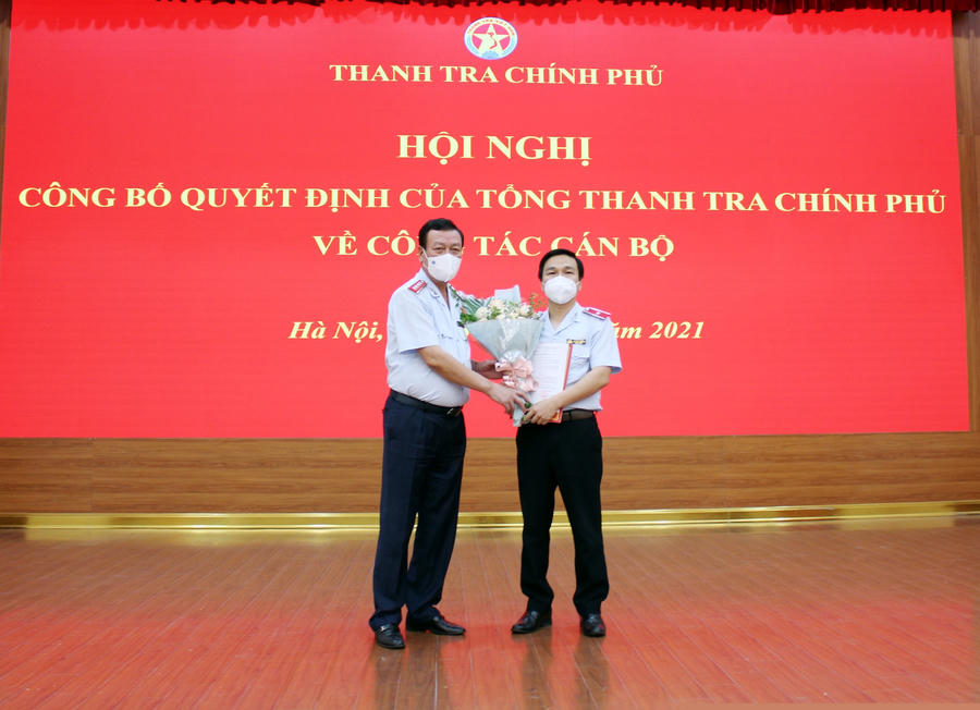 Tổng Thanh tra Chính phủ Đoàn Hồng Phong trao quyết định và tặng hoa chúc mừng tân Vụ trưởng Vụ Giám sát, Thẩm định và Xử lý sau thanh tra Hoàng Hưng. Ảnh: PH
