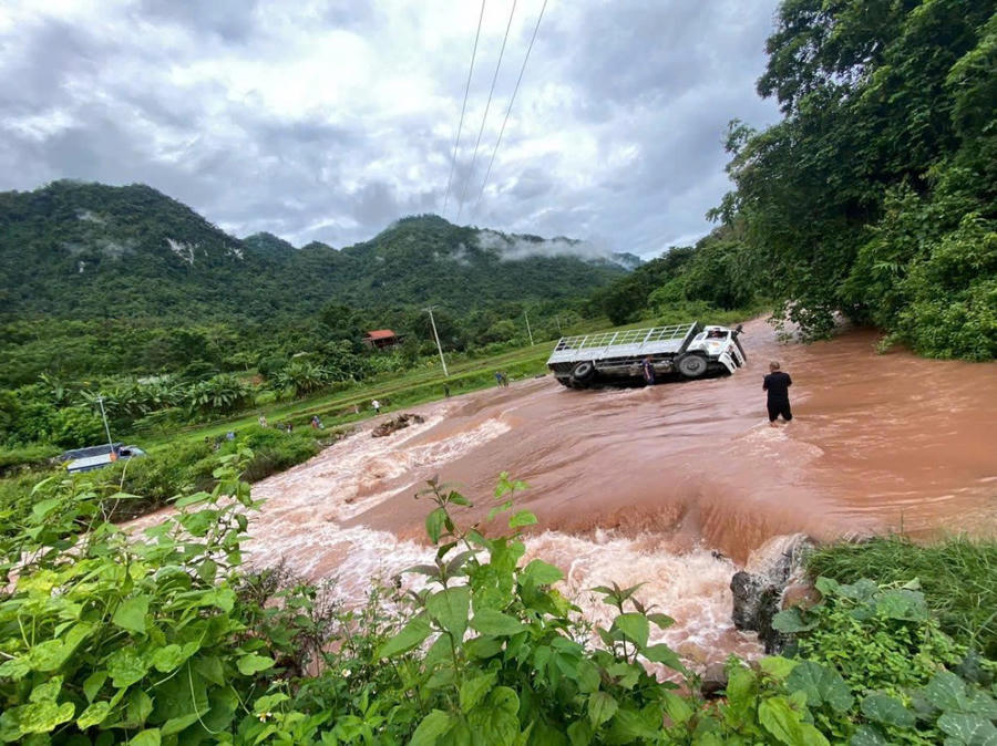Ô tô tải bị lật nghiêng khi lưu thông qua tuyến đường ngập nước.