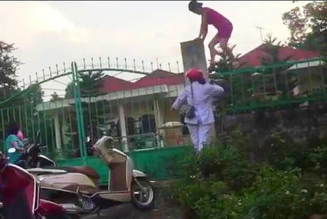 Nhân viên trung tâm nhân đạo vượt rào đưa hàng từ thiện ra ngoài (Ảnh: Giadinhvietnam).