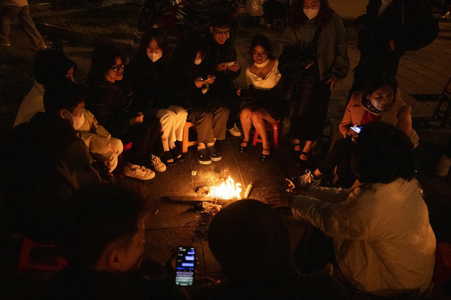 Các bạn trẻ quây quần quanh đống lửa, vừa sưởi ấm vừa tận hưởng không khí lạnh đang tràn về khắp các tuyến phố Hà Nội.