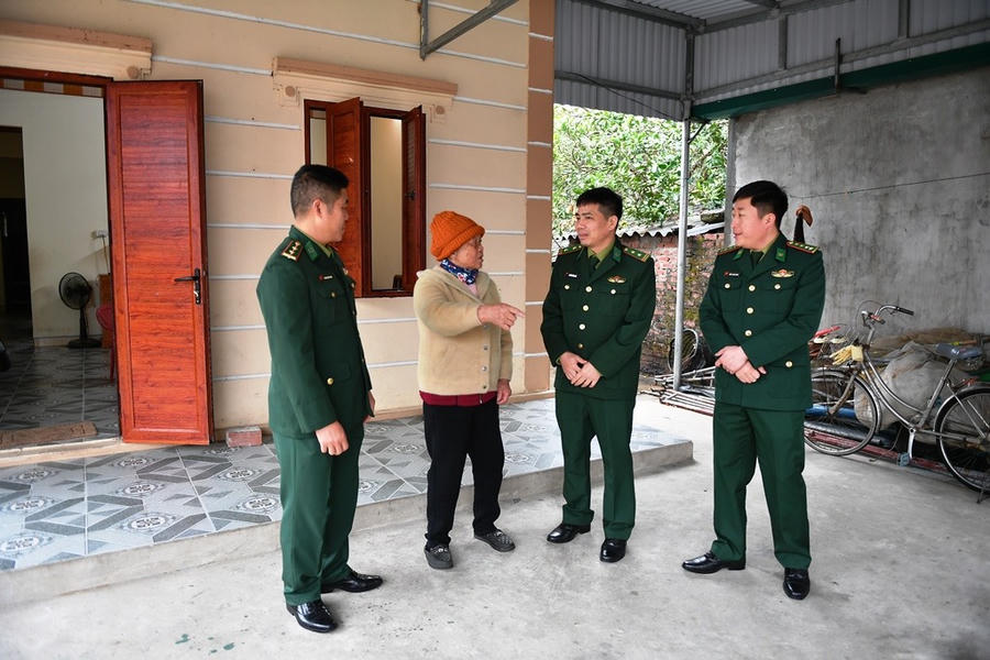 Chiến sỹ Đồn Biên phòng Trà Cổ thăm gia đình bà Vũ Thị Cơ trong căn nhà tình nghĩa mới xây.