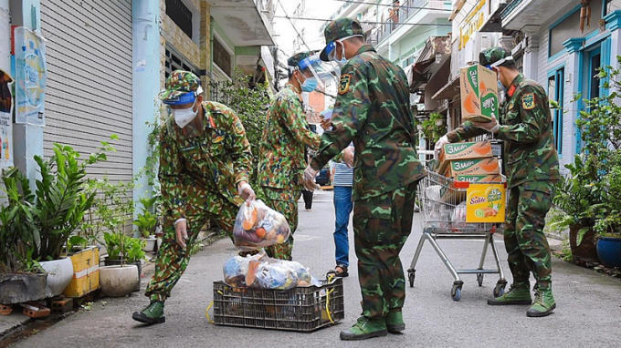 Bộ đội phát nhu yếu phẩm đến từng nhà dân.