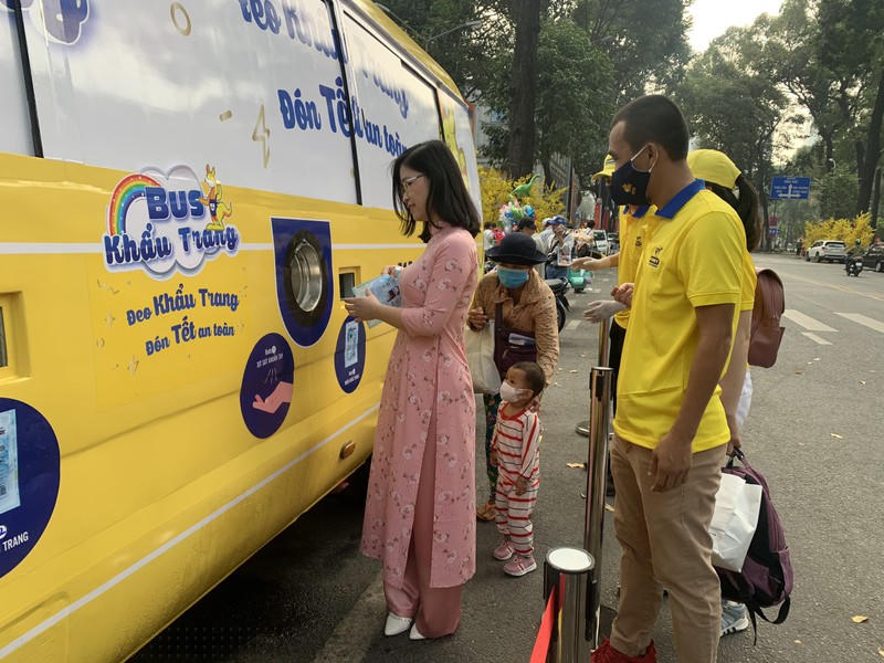 Người dân thành phố xếp hàng nhận khẩu trang tại xe bus khẩu trang.