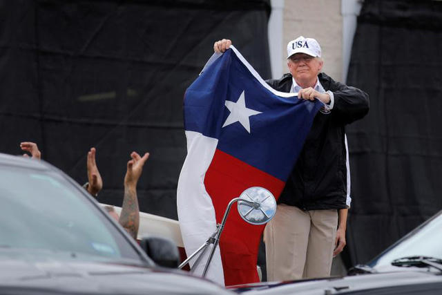 Đây là chuyến thị sát đầu tiên của Tổng thống Trump tới Texas từ sau khi cơn bão Harvey, cơn bão được đánh giá là mạnh nhất trong vòng 50 năm qua, đổ bộ vào khu vực này. Ông Trump đã gặp gỡ các lãnh đạo địa phương và người dân để nghe báo cáo về tình hình thiên tai. Trong ảnh: Tổng thống Trump cầm cờ của bang Texas gặp gỡ người dân ở Corpus Christi. (Ảnh: Reuters)