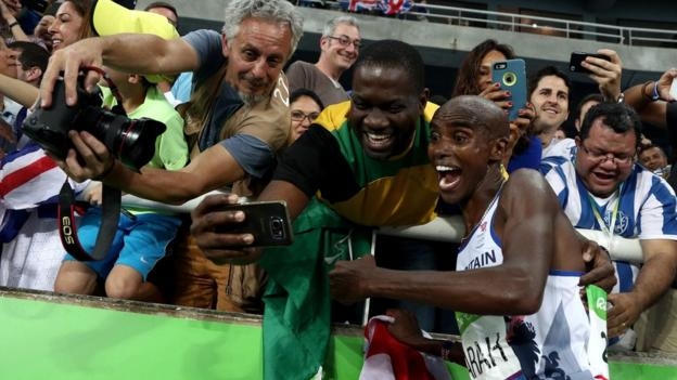 VĐV Mo Farah của Vương quốc Anh ăn mừng với CĐV sau khi hoàn tất cú đúp HCV ở Olympic 2016. Anh trở thành người thứ hai, sau Lasse Viren của Phần Lan bảo vệ thành công chức vô địch ở 2 cự ly chạy 5.000m và 10.000m. Với 4 HCV giành được, Mo Farah là một trong những VĐV thành công nhất xứ sở sương mù ở đấu trường Olympic.