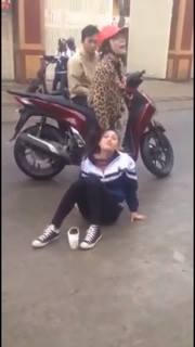 Cô gái đội mũ bảo hiểm màu đỏ liên tục hành hung nữ sinh (ảnh cắt từ clip)