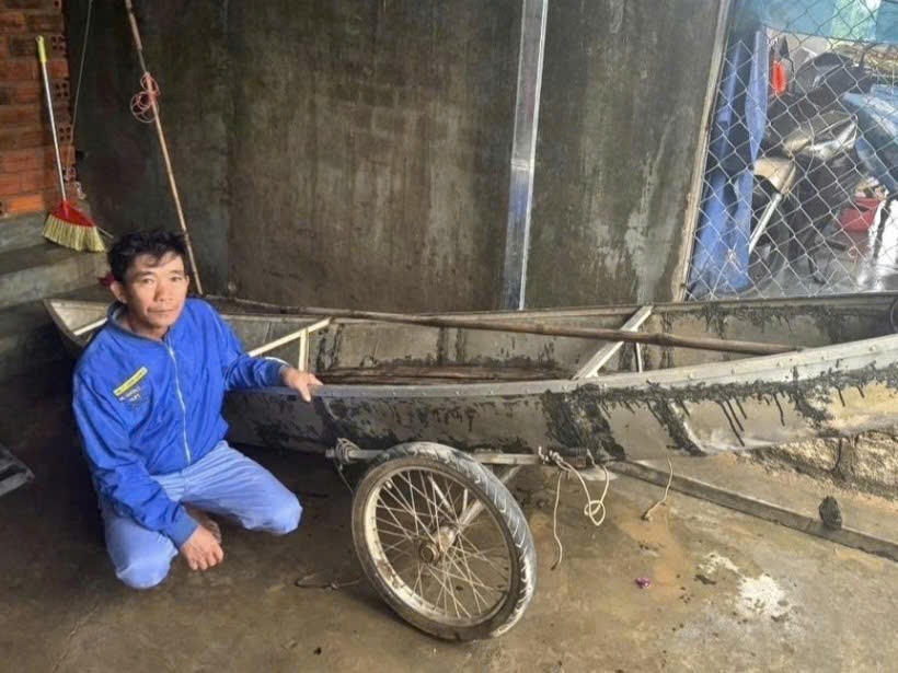 Anh Thành bên chiếc ghe cắt cỏ của gia đình. Ảnh: Hải Dương