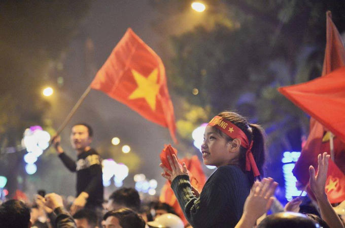 Một em bé theo cha mẹ ra Hồ Gươm sau chiến thắng của đội tuyển U23 Việt Nam ở trận bán kết. Ảnh Trần Thường