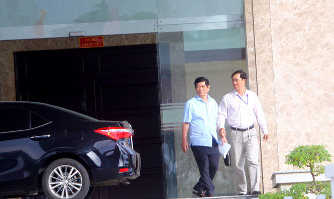 Ông Nguyễn Phong Quang (áo xanh, bên trái) bước ra cổng Ban Chỉ đạo Tây Nam bộ sau buổi họp triển khai kết luận của Ủy ban Kiểm tra trung ương chiều 22-8 - Ảnh: CHÍ QUỐC.