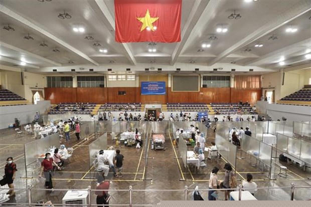 Tại điểm tiêm chủng Nhà thi đấu Trịnh Hoài Đức, lực lượng chức năng đã dựng tấm vách ngăn, tạo thành các ô vuông riêng biệt, từ vị trí khám sàng lọc tới vị trí tiêm đều có khoảng cách để đảm bảo giãn cách. (Ảnh: Minh Quyết/TTXVN)