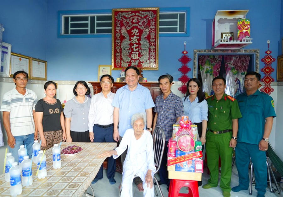 Ông Phạm Thành Ngại – Phó Bí thư Tỉnh ủy, Chủ tịch UBND tỉnh Cà Mau (thứ 5, từ trái sang), tặng quà và cùng đại diện các sở, ngành, địa phương chụp ảnh lưu niệm với gia đình Mẹ Hồ Thị Năm (phường Láng Tròn).