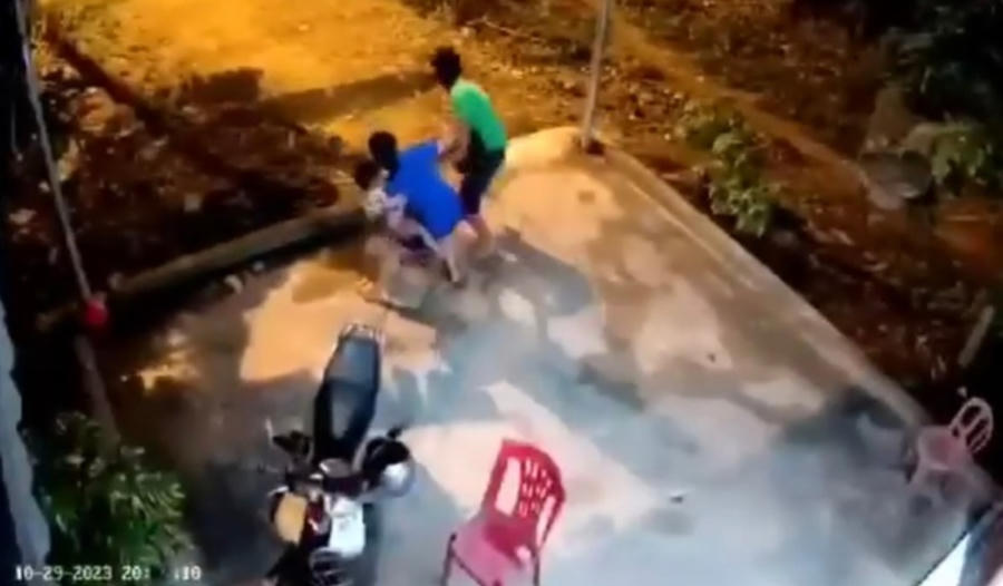 Người bố lao từ nhà ra đạp thẳng vào người bé. Ảnh Cắt từ clip.