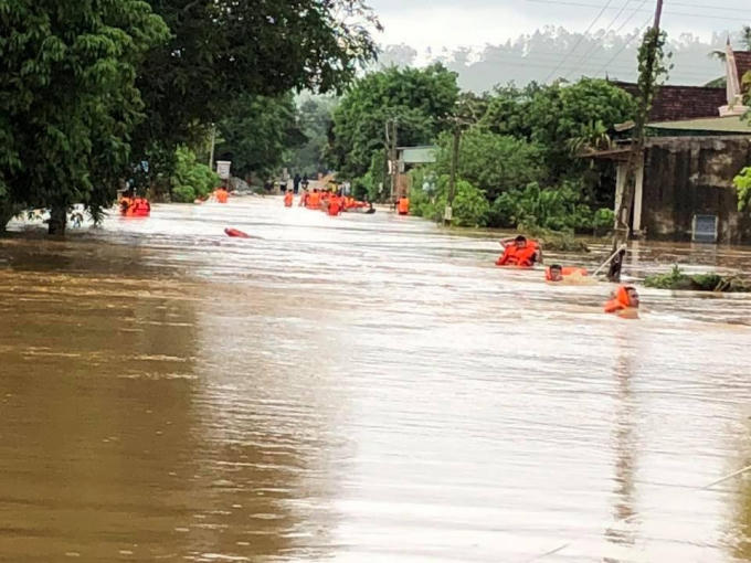Lực lượng công an huyện Qùy Hợp ngâm mình trong nước lũ tiếp cận những hộ dân bị ngập sâu (ảnh CAQH).