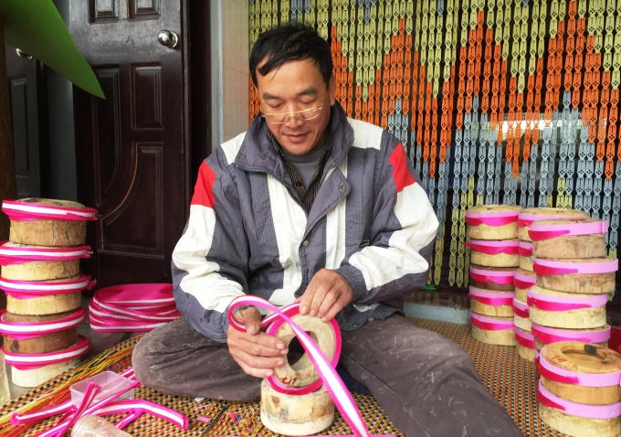 Ông Nguyễn Văn Kháng, 50 tuổi, nghệ nhân làm khăn xếp thôn Giáp Nhất quấn mỗi ngày 100 chiếc khăn đóng để có thể có đủ hàng phục vụ cho dịp Tết. (Ảnh: Minh Trang)