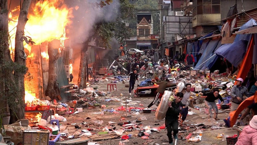 Người dân khẩn trương dập đám cháy và mang vác hàng hóa ra khỏi đám cháy. (Ảnh: Mai Thức).