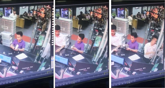 Chiếc điện thoại được nam thanh niên đặt ví của mình lên rồi cầm theo.