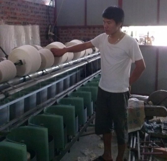 Trần Huy Quang bên hệ thống máy đánh suốt vải hiện đại nhất của mình.