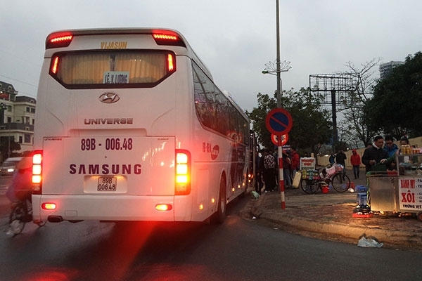 Xe chở công nhân Samsung ngang nhiên dừng đón người trên đường Phạm Hùng dù có biển cấm (Ảnh chụp lúc 6h sáng 23/2). Ảnh: Báo Giao thông