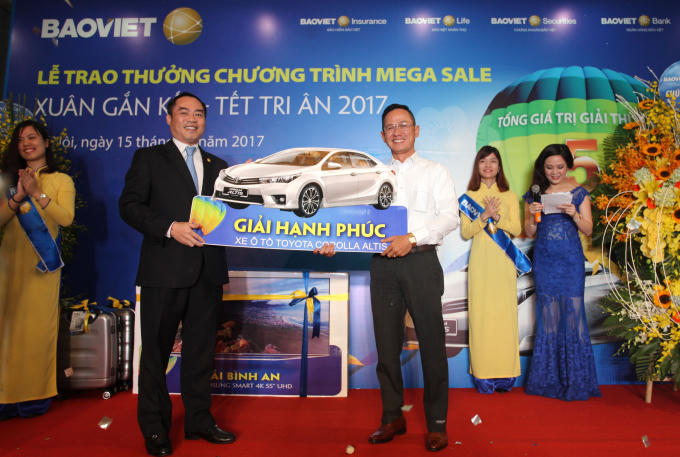 Tổng Giám đốc Tập đoàn Bảo Việt Nguyễn Quang Phi trao giải cho khách hàng may mắn.