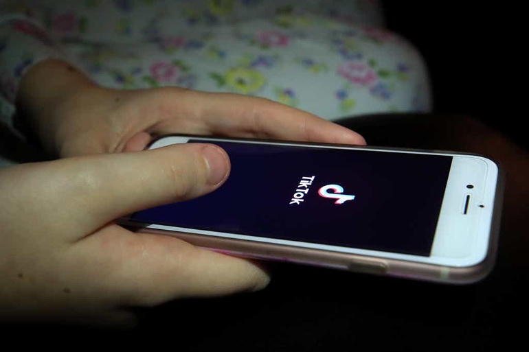 Một bé gái đang dùng ứng dụng TikTok trên smartphone (Ảnh: Peter Byrne/PA).