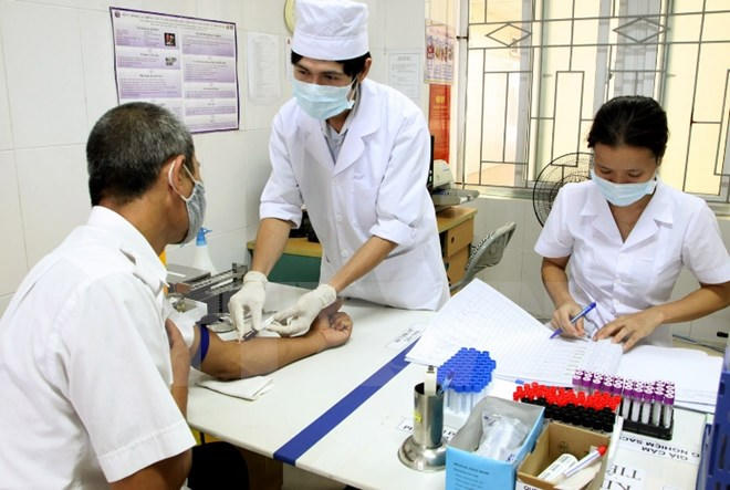 Nhân viên y tế lấy máu xét nghiệm cho bệnh nhân. Ảnh: Dương Ngọc/TTXVN