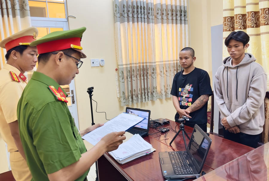 Cơ quan Cảnh sát điều tra tống đạt quyết định khởi tố bị can, lệnh cấm đi khỏi nơi cư trú đối với Võ Duy Khang (áo đen) và Phạm Văn Ý (áo xám).